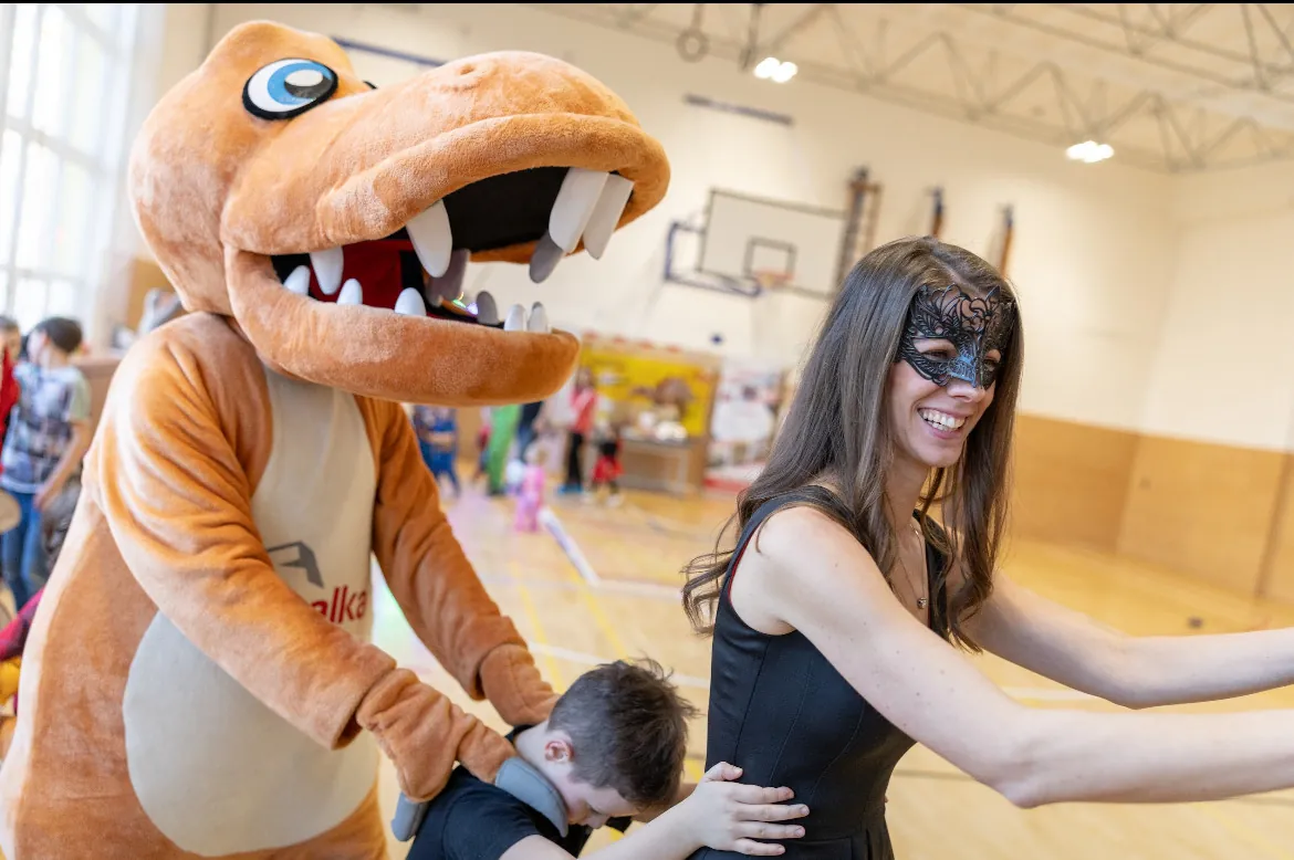 Nekonečný karneval — dinosauří maskot a moderátorka
