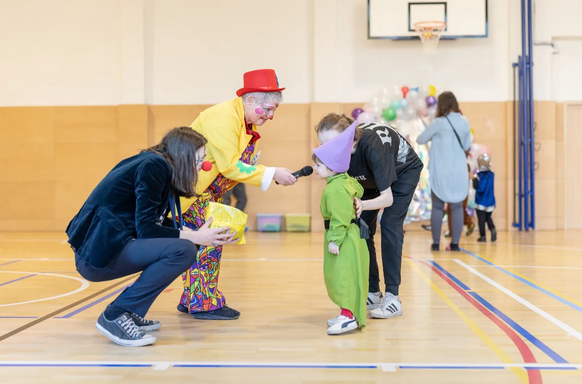Nekonečný karneval — klaun s mikrofonem a děti