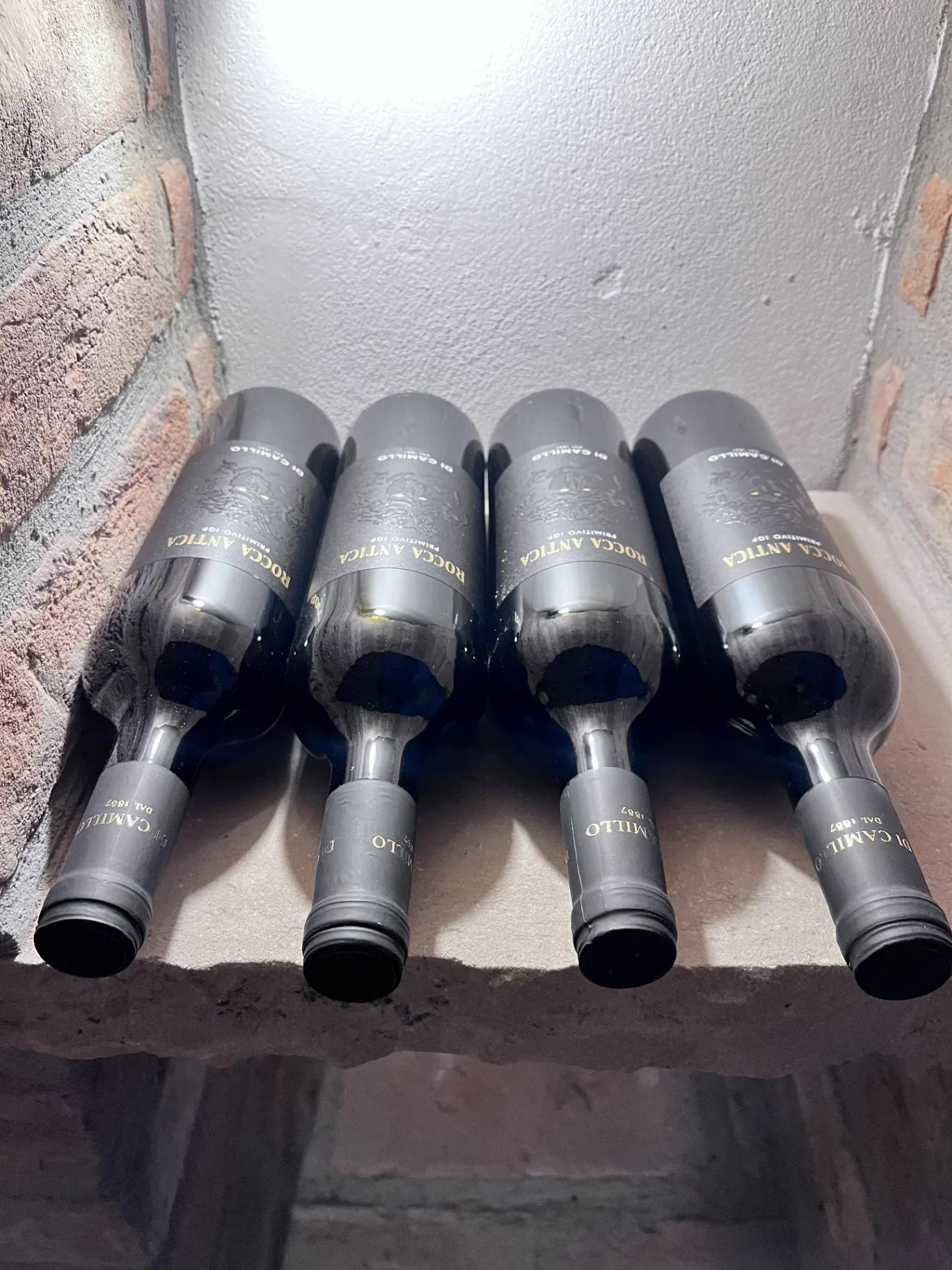Lahve Rocca Antica Primitivo uložené v regálu